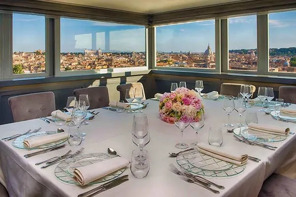 Sala panoramica della Casina Valadier con tavolo apparecchiato e vista su Roma
