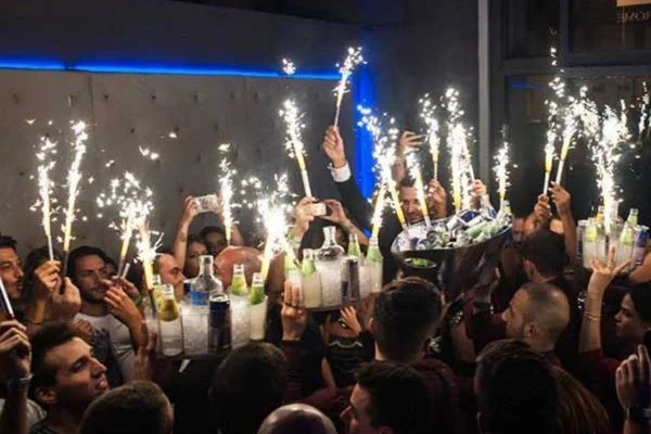 Bottiglie con sparkler servite ai tavoli della discoteca dell’Exe Roma