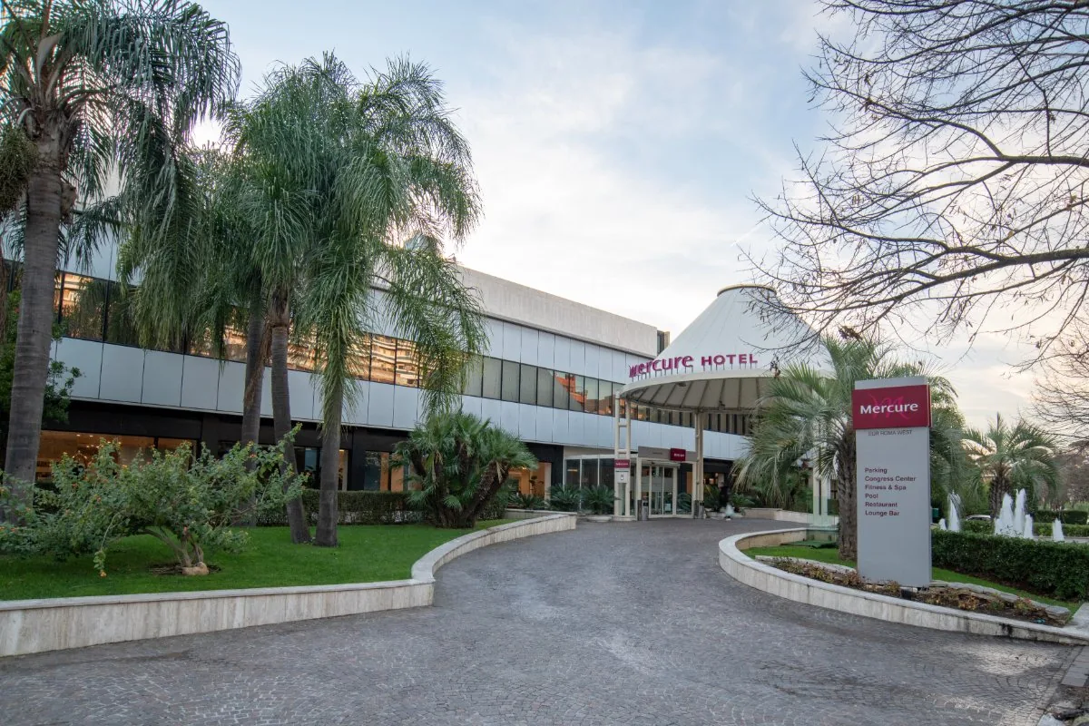 Ingresso esterno del Mercure Roma West con viale alberato e insegna dell’hotel