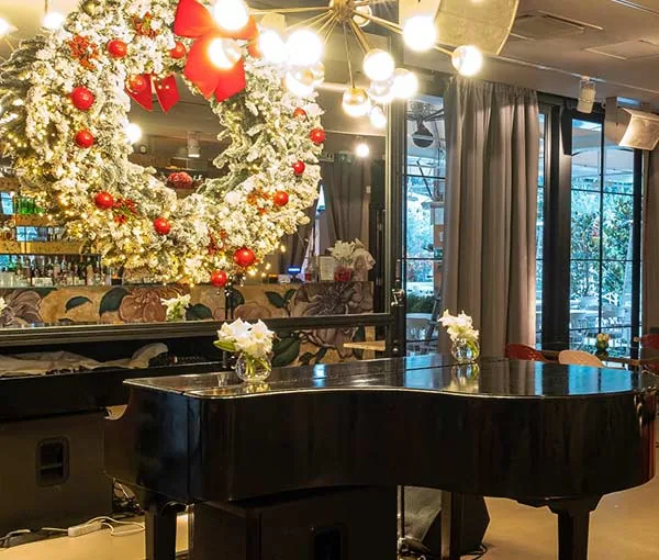 Pianoforte a coda e decorazioni natalizie nella sala di Profumo