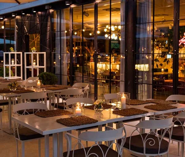 Sala ristorante di Profumo con tavoli apparecchiati e vetrate