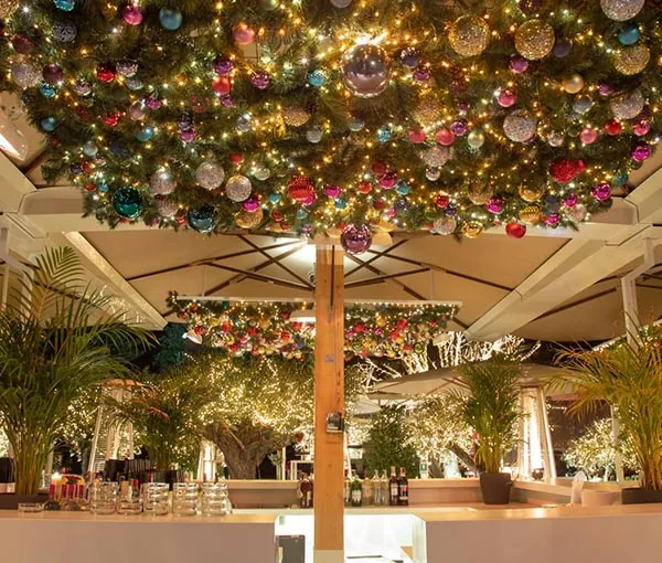 Soffitto decorato con addobbi natalizi sopra i tavoli di Profumo