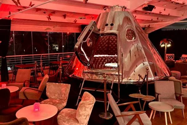 Area lounge del Qvinto con luci rosse e arredi di design