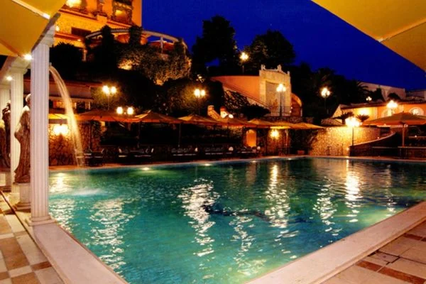 Sala della Residenza Castelverde con tavoli rotondi e sedute blu
