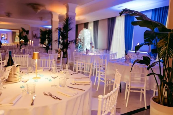 Sala di Villa Cassia allestita con tavoli bianchi e luci scenografiche