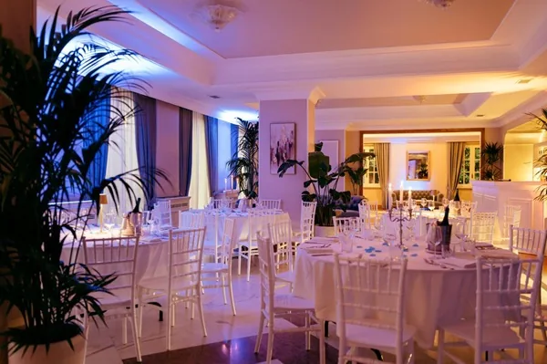 Sala interna di Villa Cassia con tavoli bianchi apparecchiati