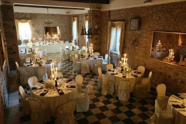 Sala in mattoni di Villa Grant a Roma con tavoli rotondi apparecchiati